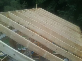 New roof rafters set over an addition before sheathing in Hopwood