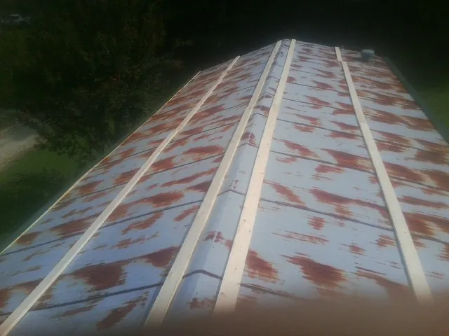 Rusted metal roof panels with new wood purlins before replacement — Storm Damage Roof Repair in Hopwood by Roofing Brothers