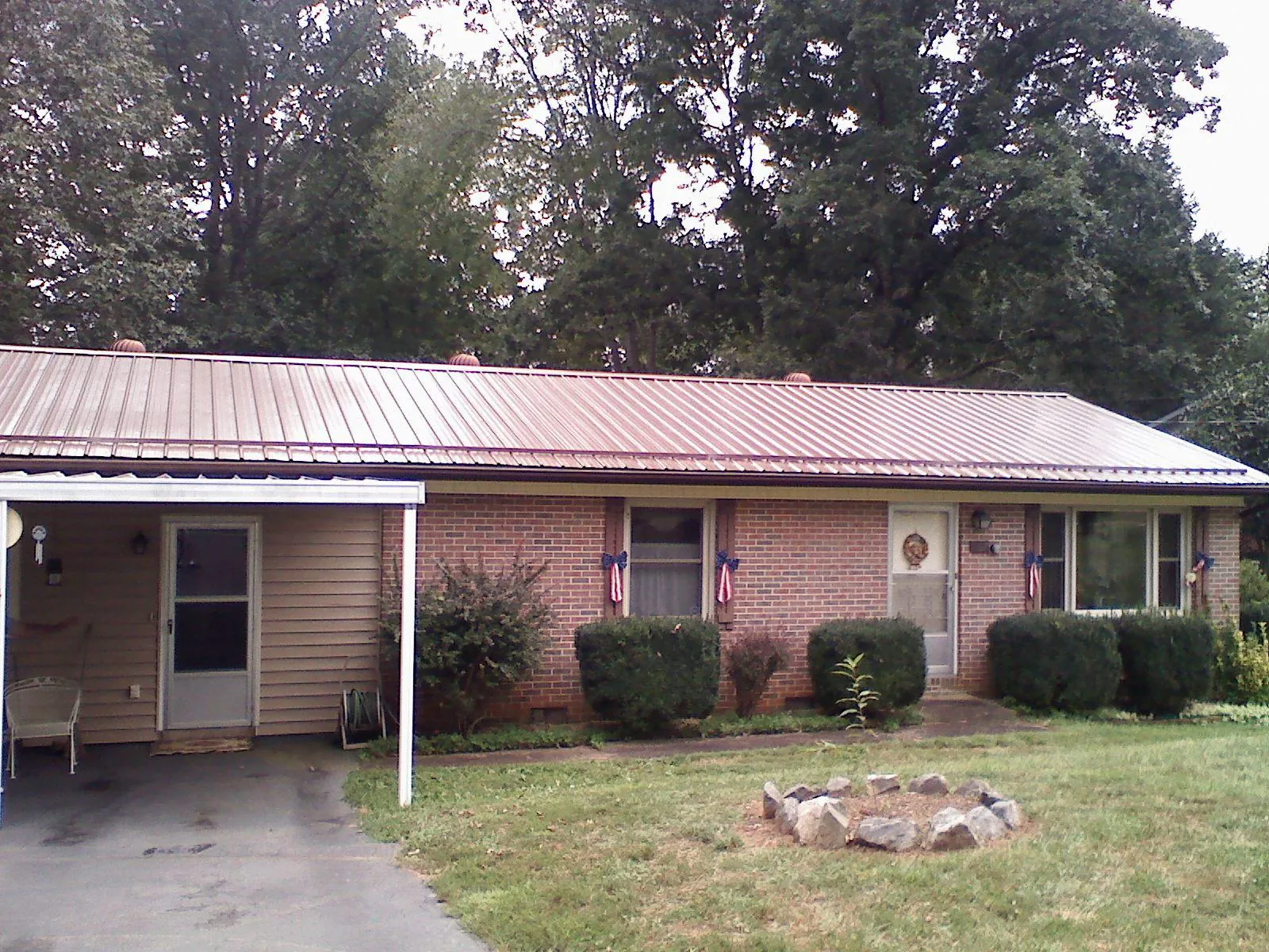 Bronze metal roof and carport on a brick ranch home — Roof Repair work by our crew in Hopwood