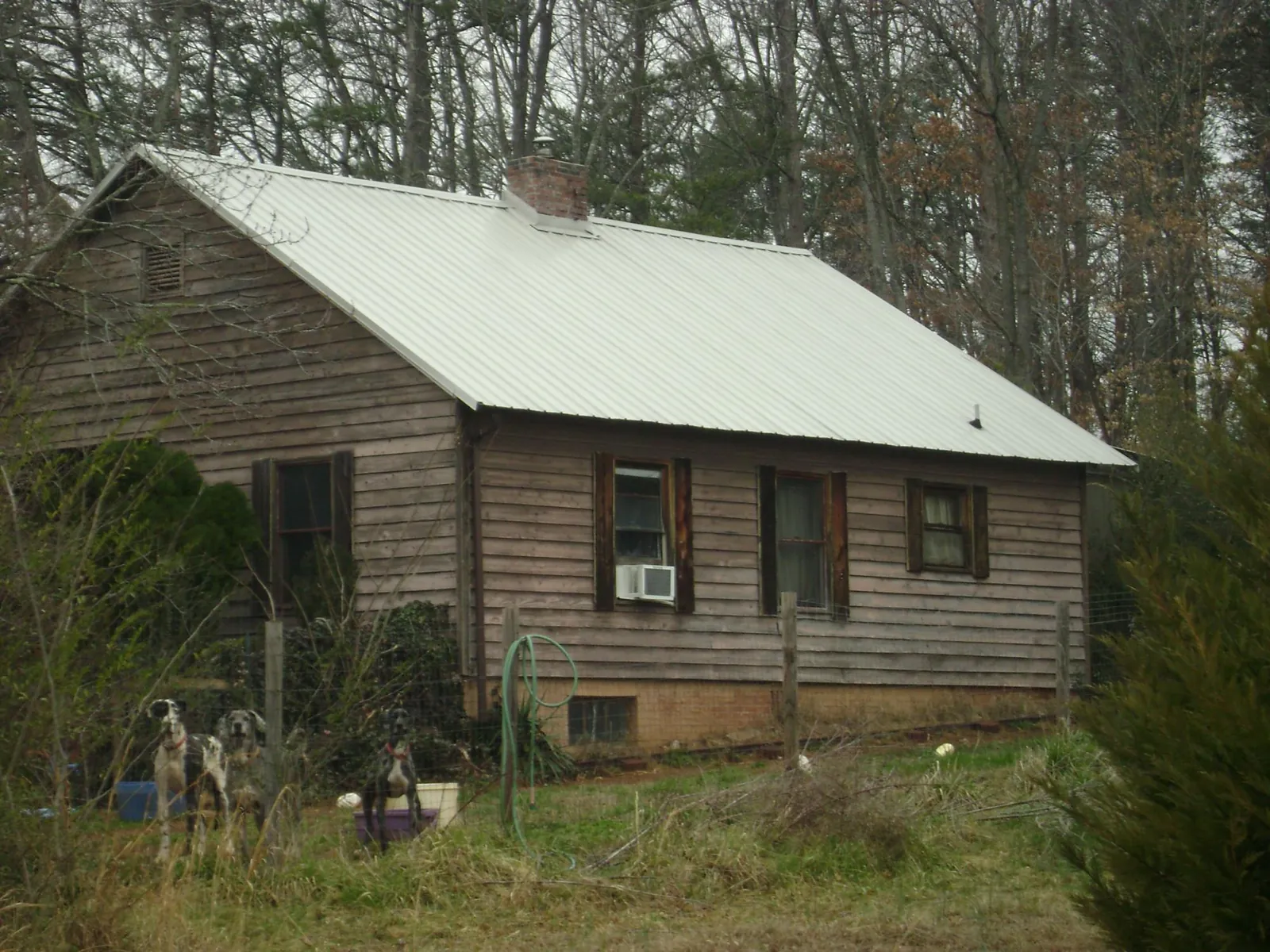 White metal roof on an old wood sided farmhouse, from a Metal Roof Installation job in Hopwood